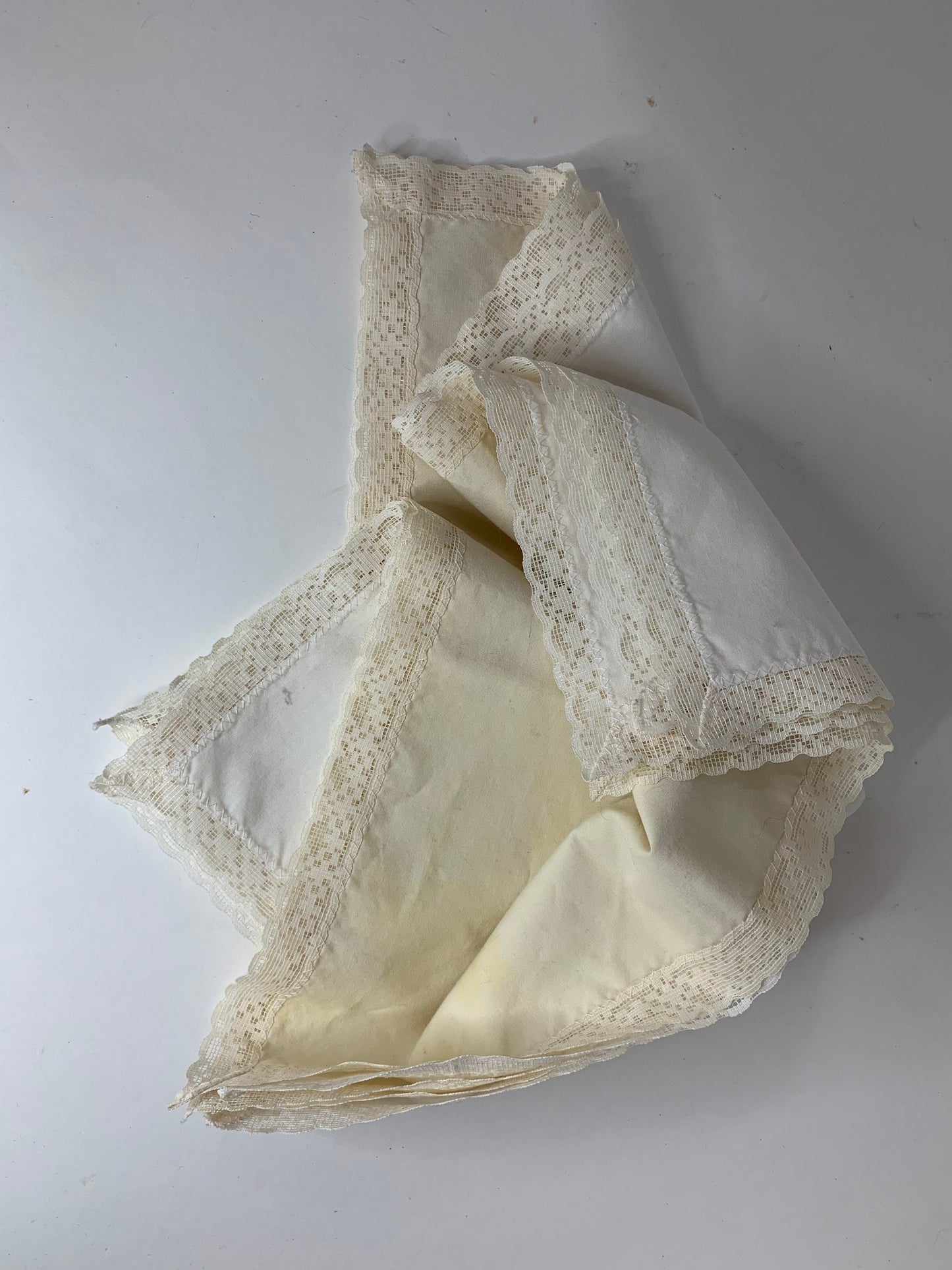 Four ivory cotton and lace dinner napkins